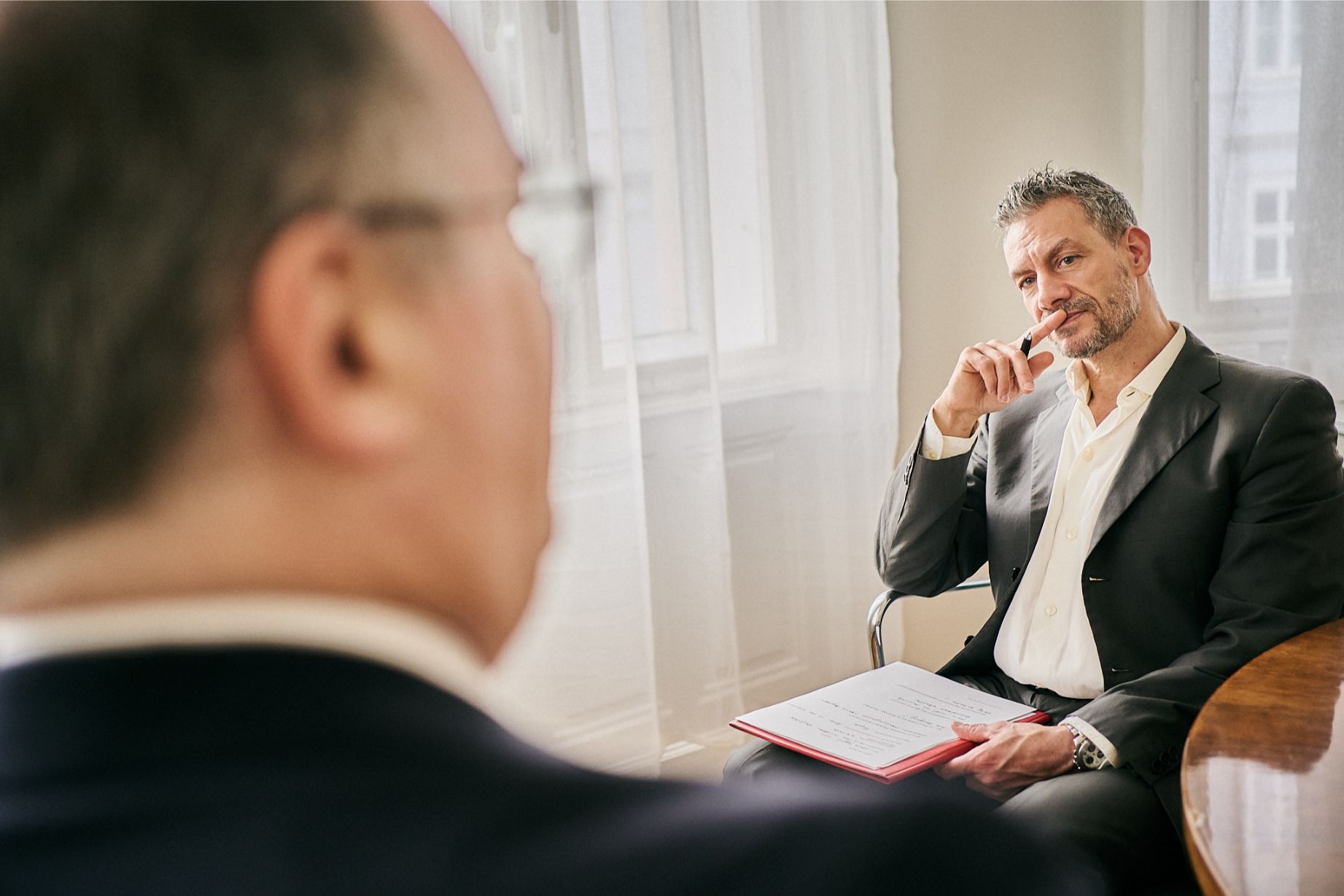 Personal Trainer Karim hört aufmerksam zu und analysiert Ziele eines Kunden im persönlichen Coaching in Wien.